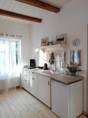 a kitchen with white cabinets and a counter top at Pālena apartamenti in Tērvete