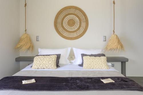 a bedroom with a bed with white sheets and pillows at Iliades Luxury Boutique Suites in Batsi
