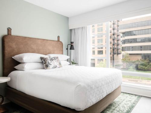 una camera da letto con un letto bianco e una grande finestra di Holiday Inn Express St. Louis Central West End, an IHG Hotel a Saint Louis
