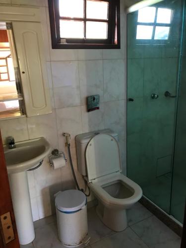 a bathroom with a toilet and a sink and a shower at Pousada Acacia Imperial in Aldeia Velha