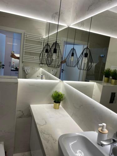 a white bathroom with a sink and a mirror at ApartPark Albus1 in Świnoujście