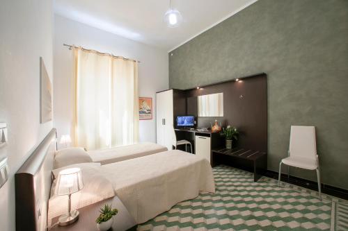 a hotel room with a bed and a desk and a television at Terrazze Villanova in Trapani