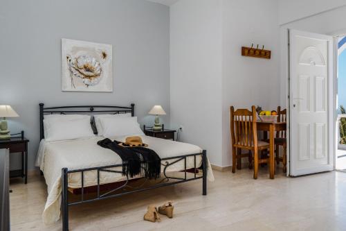 a bedroom with a bed and a table and a chair at Stavros Villas in Karterados