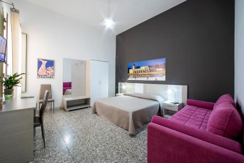 トラーパニにあるTerrazze Villanovaのベッドルーム(ベッド1台、紫色のソファ付)