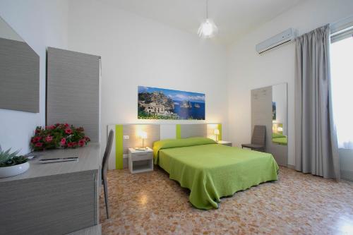 a bedroom with a green bed and a desk at Terrazze Villanova in Trapani