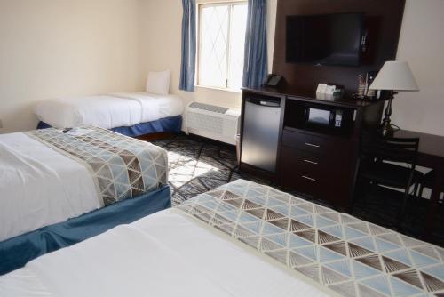 a hotel room with two beds and a flat screen tv at Frankenmuth Motel in Frankenmuth