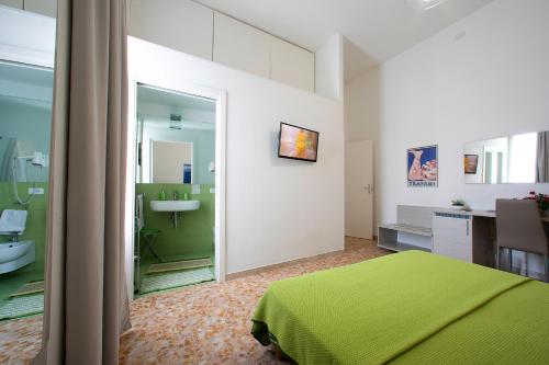 a bedroom with a green bed and a bathroom at Terrazze Villanova in Trapani
