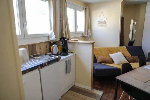 Il comprend une petite cuisine et un salon avec un canapé. dans l'établissement Grand studio, à Boulogne-sur-Mer