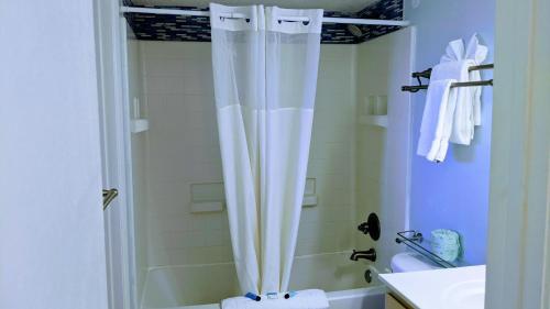ein Bad mit einem Duschvorhang und einem Waschbecken in der Unterkunft Shell Island Resort - All Oceanfront Suites in Wrightsville Beach