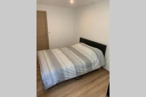 - une petite chambre avec un lit et une couverture rayée dans l'établissement Appartement neuf 4-6 personnes en bord de Mer, à Nice