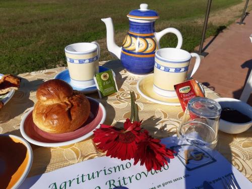 a table with a breakfast of croissants and tea cups at Agriturismo Il Gelsomino Ritrovato in Milazzo