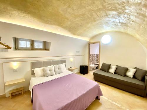 1 dormitorio con 1 cama y 1 sofá en Il Sorriso Dei Sassi Rooms en Matera