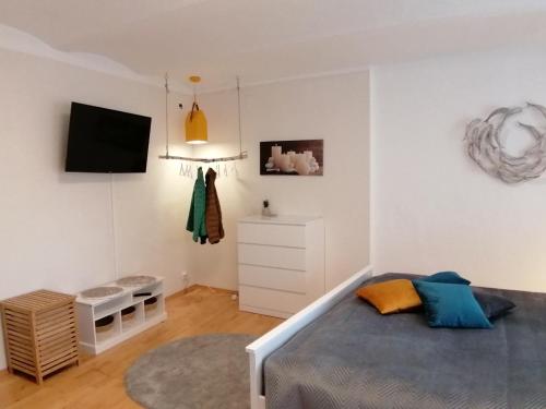 - une chambre avec un lit et une télévision murale dans l'établissement Ferienwohnung Familie Rauch, à Feldkirchen in Kärnten