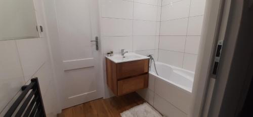 a white bathroom with a sink and a bath tub at Może nad morze in Gdańsk