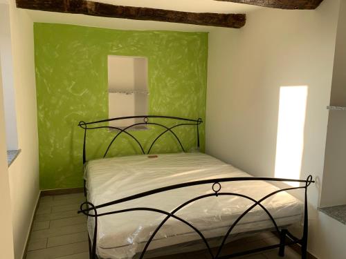 Bett in einem Zimmer mit grüner Wand in der Unterkunft Casa Francesco App Giulia in Rocchetta