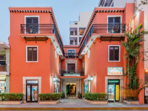 an orange building in a city at Casa del Balam Merida in Mérida