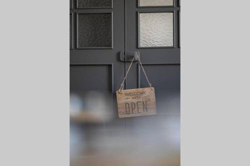 une porte avec un panneau indiquant « bienvenue ouverte » dans l'établissement CRYSTAL, à Saint-Malo