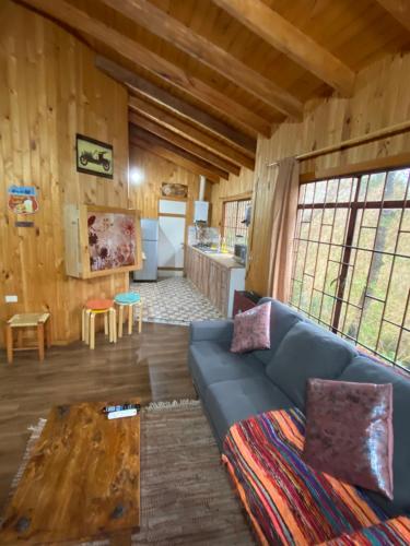 ein Wohnzimmer mit einem blauen Sofa in einer Hütte in der Unterkunft Cabañas Boutique - El Renegado Y Rustica in Recinto