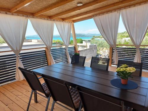 a dining room with a table and chairs on a balcony at Mobile homes Charly in Tisno