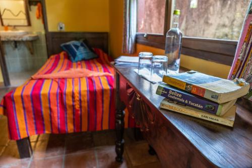 a table with books on it with a bed at La Iguana Perdida in Santa Cruz La Laguna