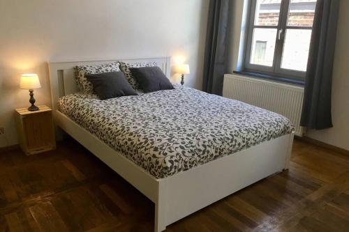 Ce lit se trouve dans une chambre dotée de 2 lampes et d'une fenêtre. dans l'établissement En plein cœur de Bruxelles. Superbe duplex.A voir!, à Bruxelles