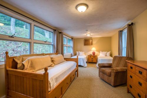a bedroom with two beds and a chair and windows at Purity Spring Resort in Madison