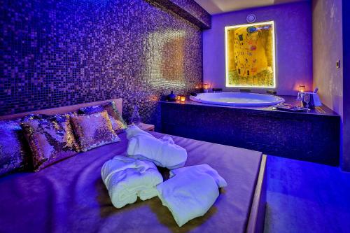 a purple bathroom with a bed and a tub at LH Parkhotel Hluboka Nad Vltavou Congress & Wellness in Hluboká nad Vltavou