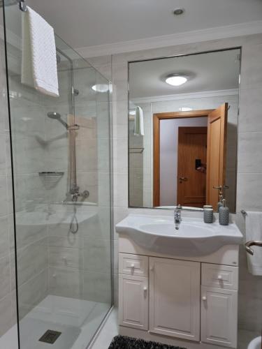 uma casa de banho com um lavatório branco e um chuveiro em Suncoast Residence V (Free parking) no Funchal