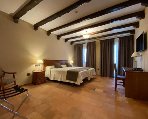 a bedroom with a bed and a table and a chair at Hotel Rural El Lagar de Nemesio in Perales de Tajuña