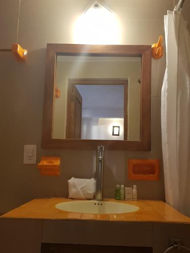 Hotel Revi Inn في فالي دي برافو: حمام مع حوض ومرآة
