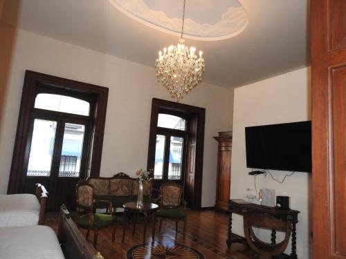 a living room with a couch and a chandelier at Hotel Marqués del Ángel in Puebla