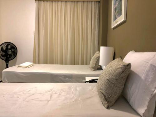 a hotel room with two beds and a window at Biarritz temporadalitoranea in São Luís