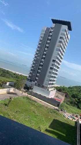 a large building with a parking lot in front of it at Biarritz temporadalitoranea in São Luís