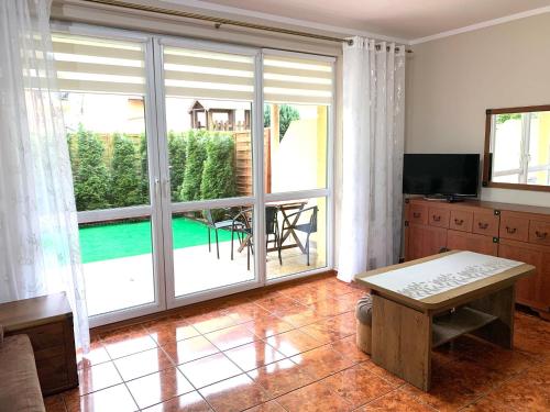 uma sala de estar com uma grande porta de vidro deslizante em Apartament Rezydencja Marino em Rewal