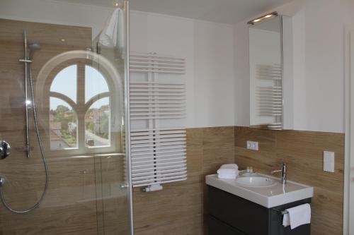 a bathroom with a sink and a glass shower at Pension Strandschloss Arielle in Börgerende-Rethwisch