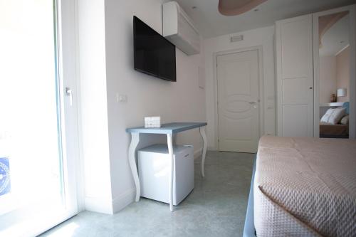 a bedroom with a table and a television on the wall at Cavalieri D'Oro Luxury House in Anzio