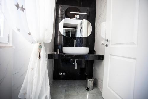 a bathroom with a sink and a mirror at Cavalieri D'Oro Luxury House in Anzio