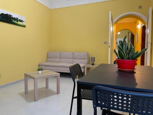uma sala de estar com uma mesa e um sofá em Lu Cori di Sossu em Sorso