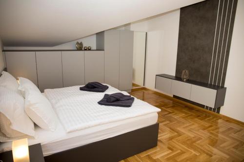 a bedroom with a bed with two towels on it at Penthouse with Old bridge view and jacuzzi in Mostar