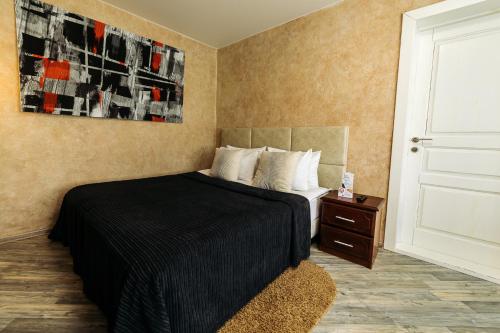 1 dormitorio con 1 cama con manta negra en City Apartments - Junior suite room en Smolensk