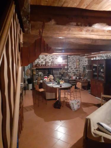 un salon avec une table et un mur en pierre dans l'établissement Maison authentique en pierre apparente en montagne dans le c antal, à Thiézac