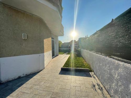 a building with the sun shining on the side of it at Climbing House Chèrie Madeleine in Lido Di Fondi