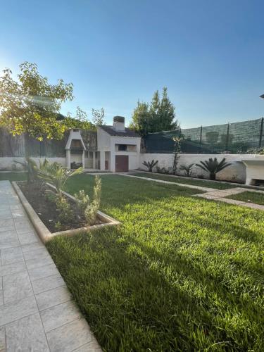 a house with a grassy yard with a driveway at Climbing House Chèrie Madeleine in Lido Di Fondi