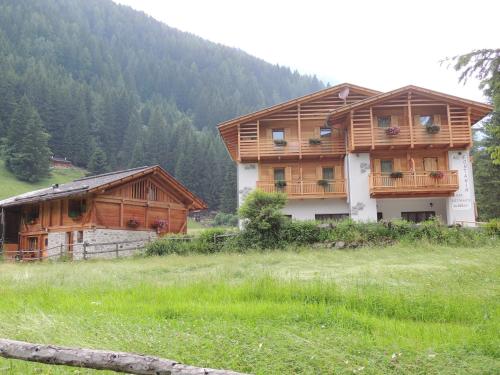 a house in a field next to a mountain at Albergo al Fontanin in Rabbi