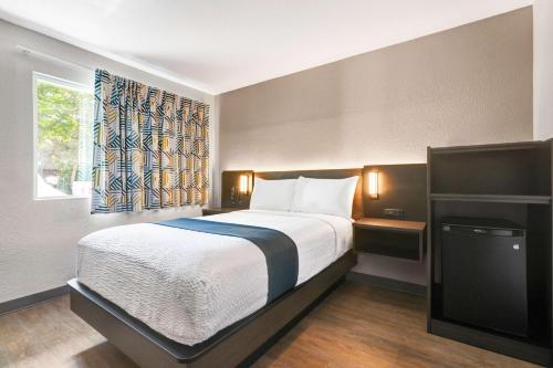 a bedroom with a bed and a window and a television at Motel 6-Issaquah, WA - Seattle - East in Issaquah