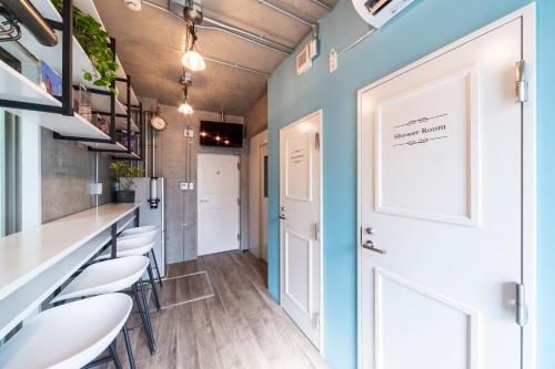 een gang met een bar met stoelen en een witte deur bij Oyado danran 団欒 in Tokyo