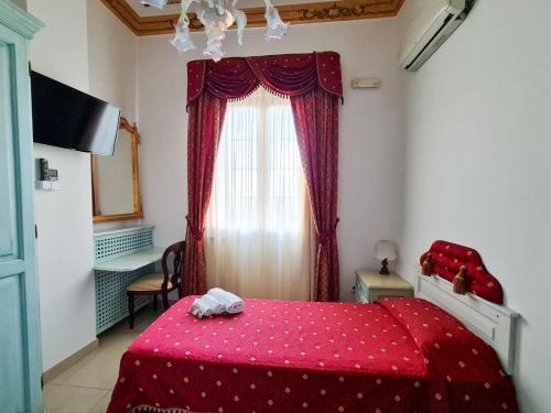 a bedroom with a red bed and a window at Euro Hotel Iglesias in Iglesias