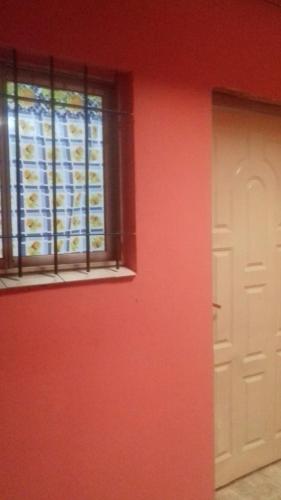 a red room with a window and a door at LO QUE HAY!!! in Ezeiza