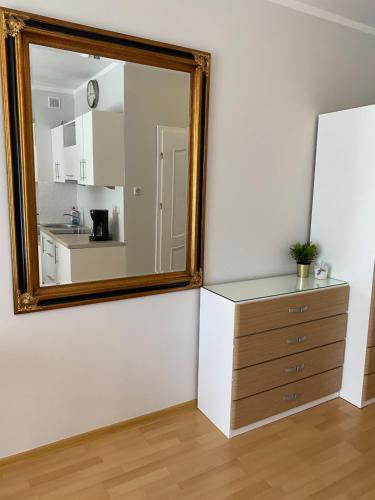 a mirror on a wall next to a dresser in a room at Apartament Comfort w Świnoujściu in Świnoujście