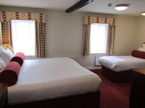 a hotel room with two beds and two windows at Windmill Village Hotel, Golf Club & Spa, BW Signature Collection in Coventry